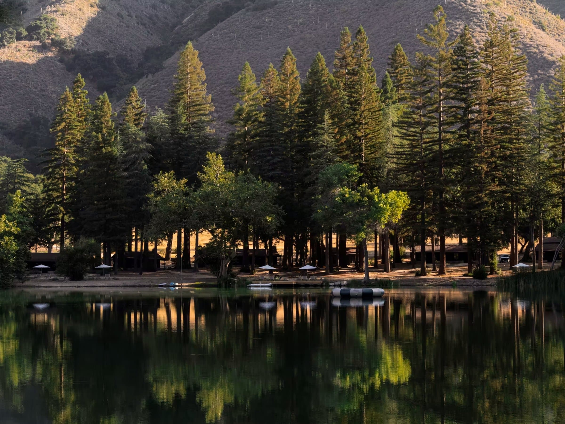 Zaca Lake — still water reflecting the pines and cabins, mountains behind